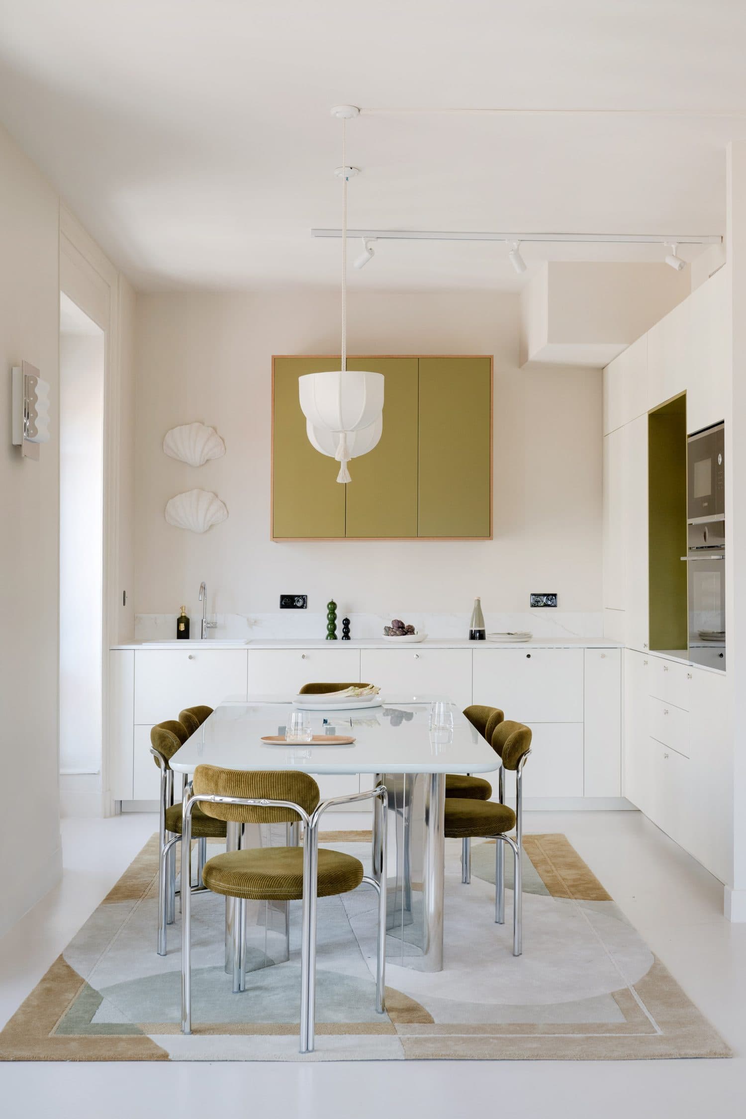 Cuisine blanche aux meubles hauts olive et table chromée